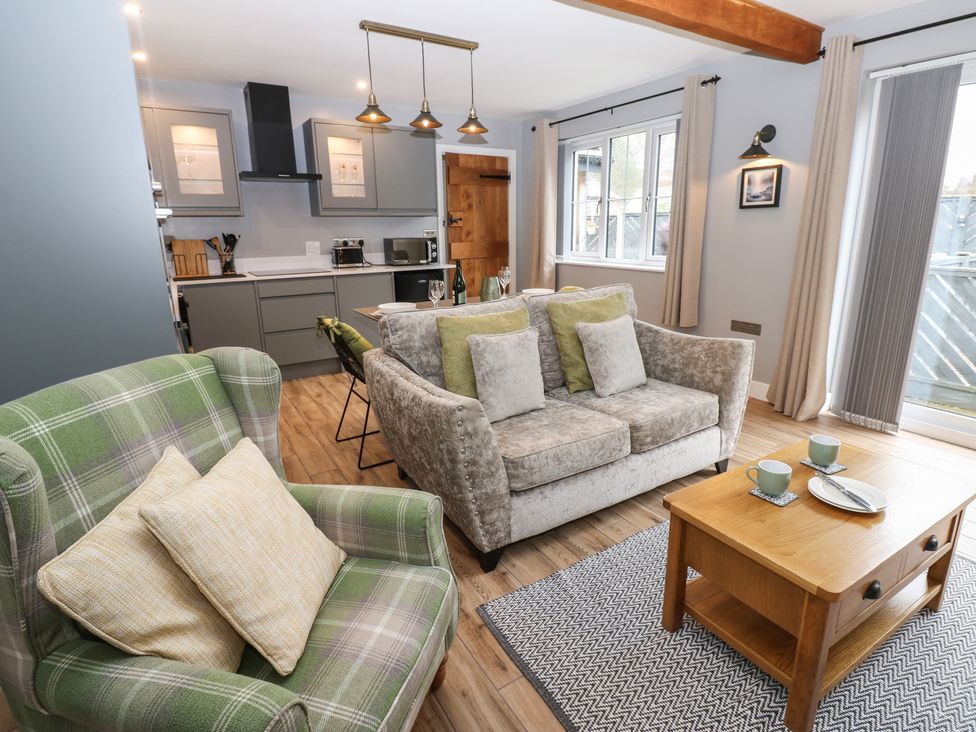 A living room with a sofa and armchair at Cobble Cottage in Long Marton near Appleby-In-Westmorland