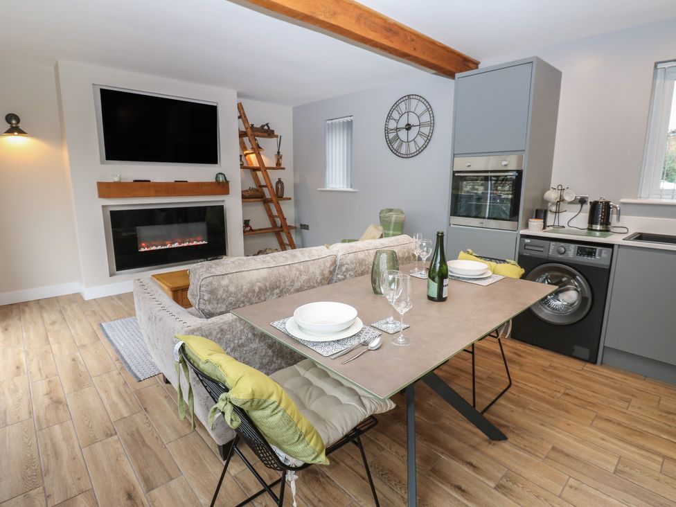 A living room with a sofa and dining table at Cobble Cottage Long Marton near Appleby-In-Westmorland