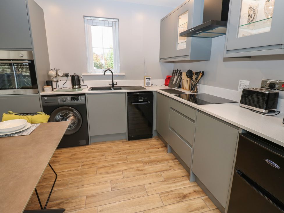 A kitchen with appliances and a table at Cobble Cottage Long Marton near Appleby-In-Westmorland