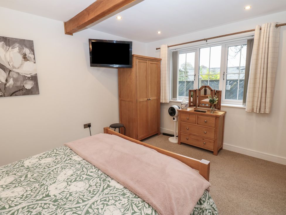 A bedroom with a bed, wardrobe, and television at Cobble Cottage in Long Marton near Appleby-In-Westmorland
