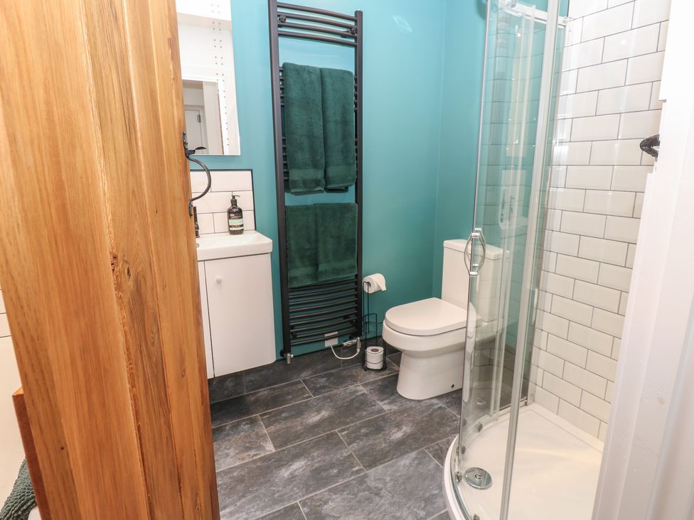 A bathroom with a shower, sink, and towel rack at Cobble Cottage Long Marton near Appleby-In-Westmorland