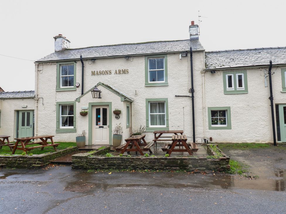 An exterior view of Masons Arms pub with benches in front at Cobble Cottage Long Marton near Appleby-In-Westmorland