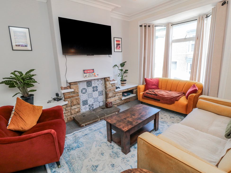 A living room with a tv and sofa at Captain Jacks in Whitby