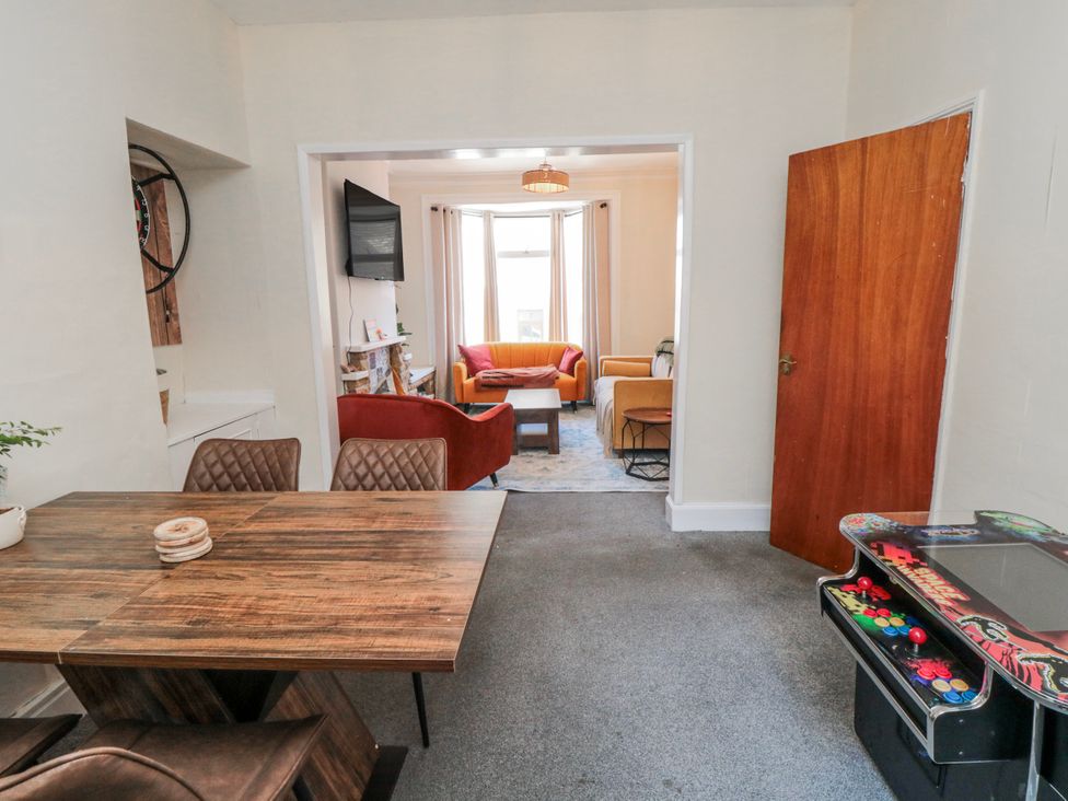 A dining room with a table and chairs and an arcade machine at Captain Jacks in Whitby