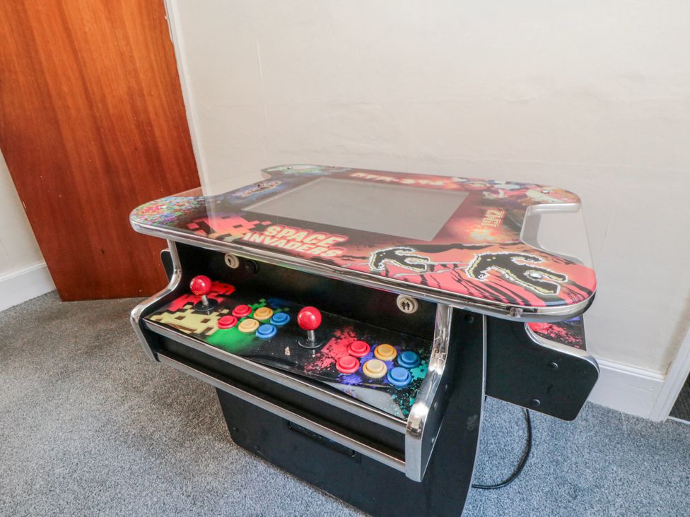 An arcade machine with colorful buttons in a game room at Captain Jacks in Whitby