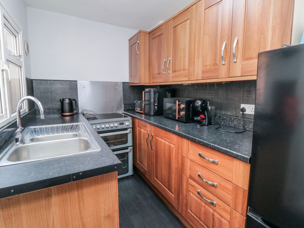 A kitchen with appliances and wooden cabinets at Captain Jacks in Whitby