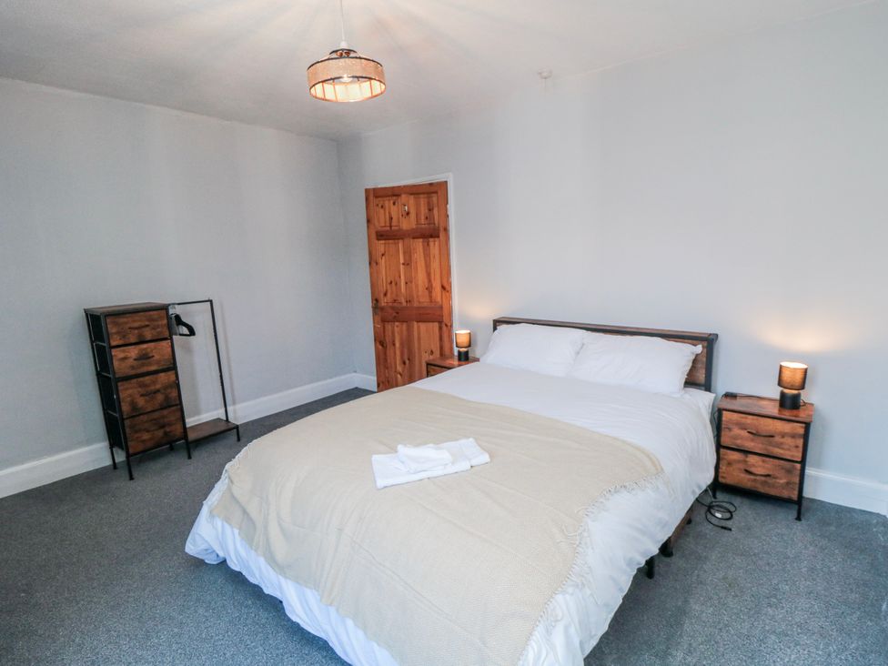 A bedroom with a bed and bedside tables at Captain Jacks in Whitby