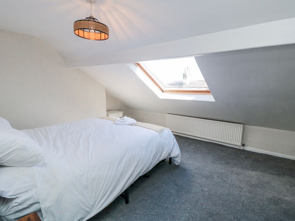 A bedroom with a bed and window at Captain Jacks in Whitby