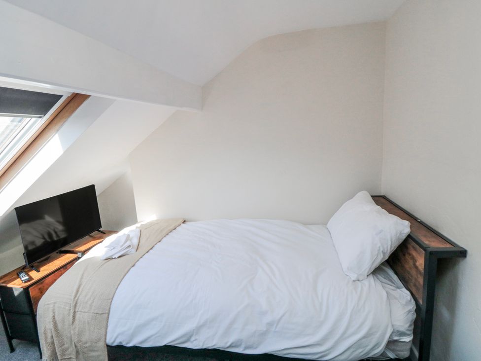 A bedroom with a bed and a TV at Captain Jacks in Whitby