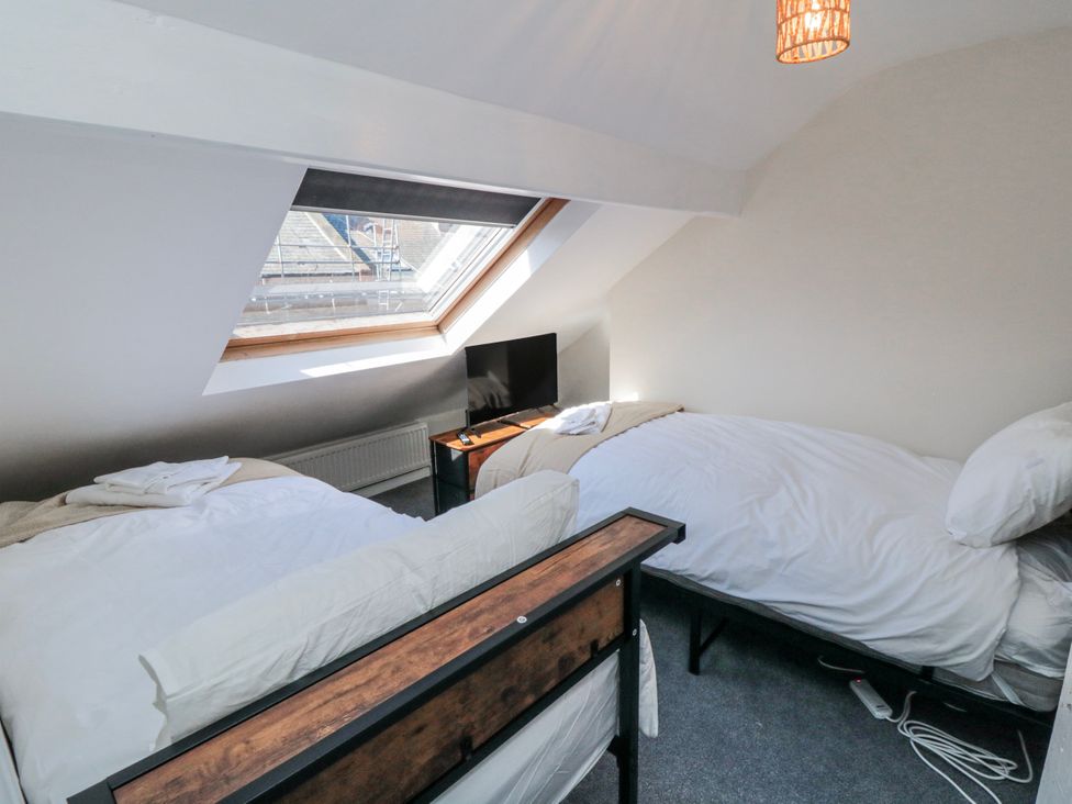 A bedroom with two beds and a television at Captain Jacks in Whitby