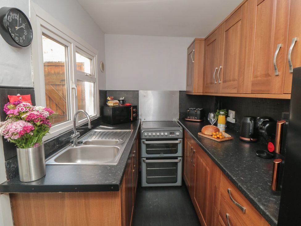 A kitchen with a sink, cooker, and kitchen appliances at Captain Jacks in Whitby