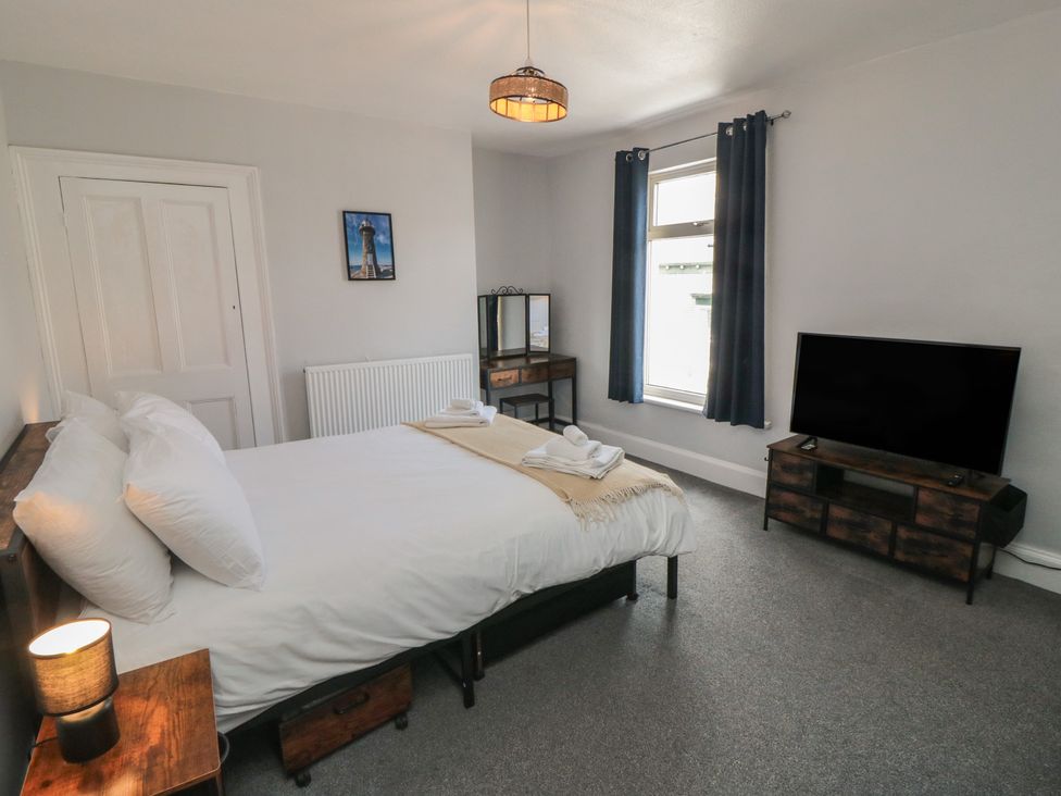 A bedroom with a bed and television at Captain Jacks in Whitby