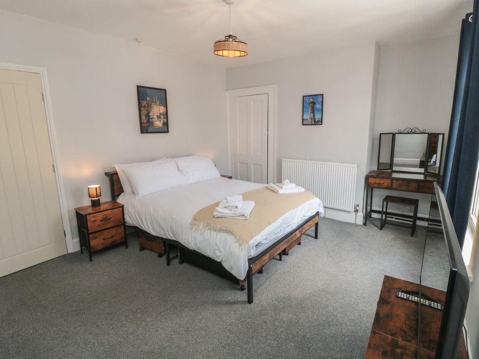 A bedroom with a bed and nightstand at Captain Jacks in Whitby