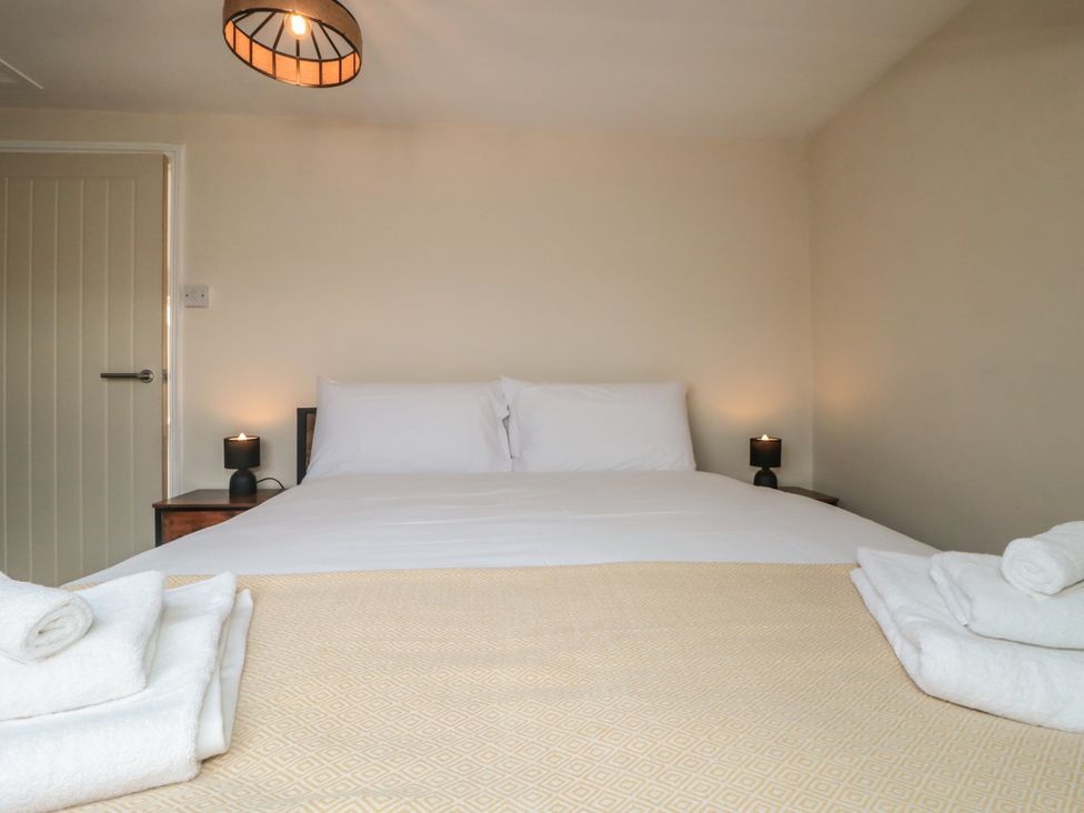 A bedroom with a bed and nightstands at Captain Jacks in Whitby