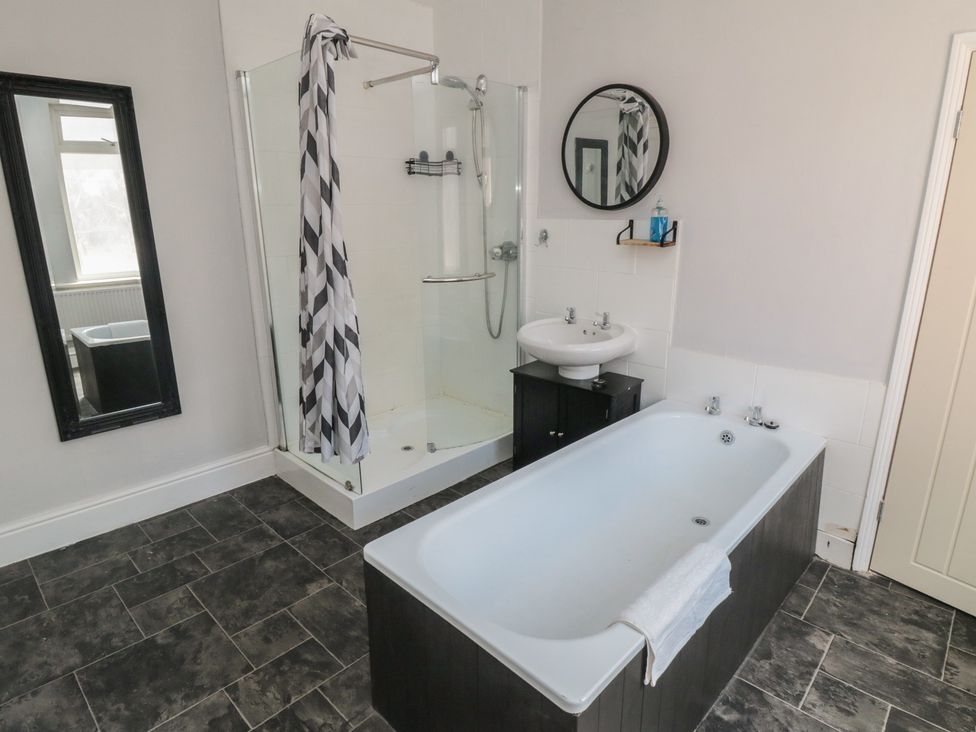 A bathroom with a shower and bathtub at Captain Jacks in Whitby