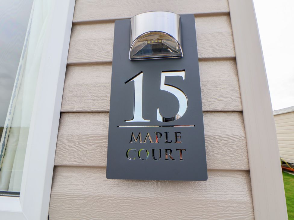 A house sign showing number 15 and name Maple Court