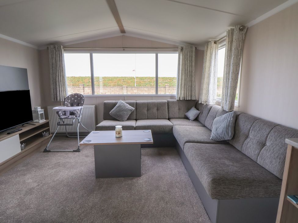 A living room with a sofa and television at MC15 in Rhyl