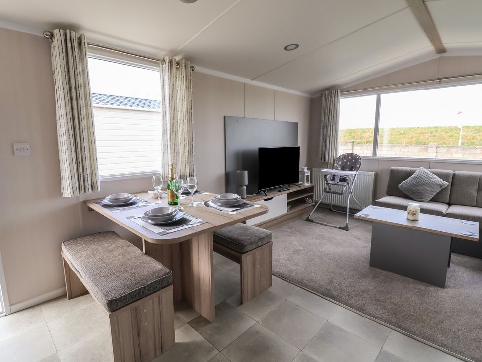 A living room with a dining table and sofa at MC15 Rhyl