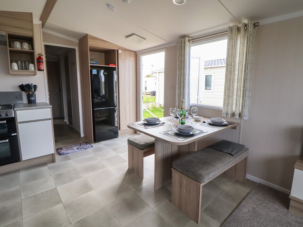 A kitchen with a table and chairs at MC15 in Rhyl