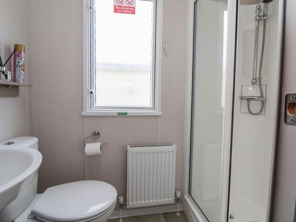 A bathroom with a shower and toilet at MC15 in Rhyl