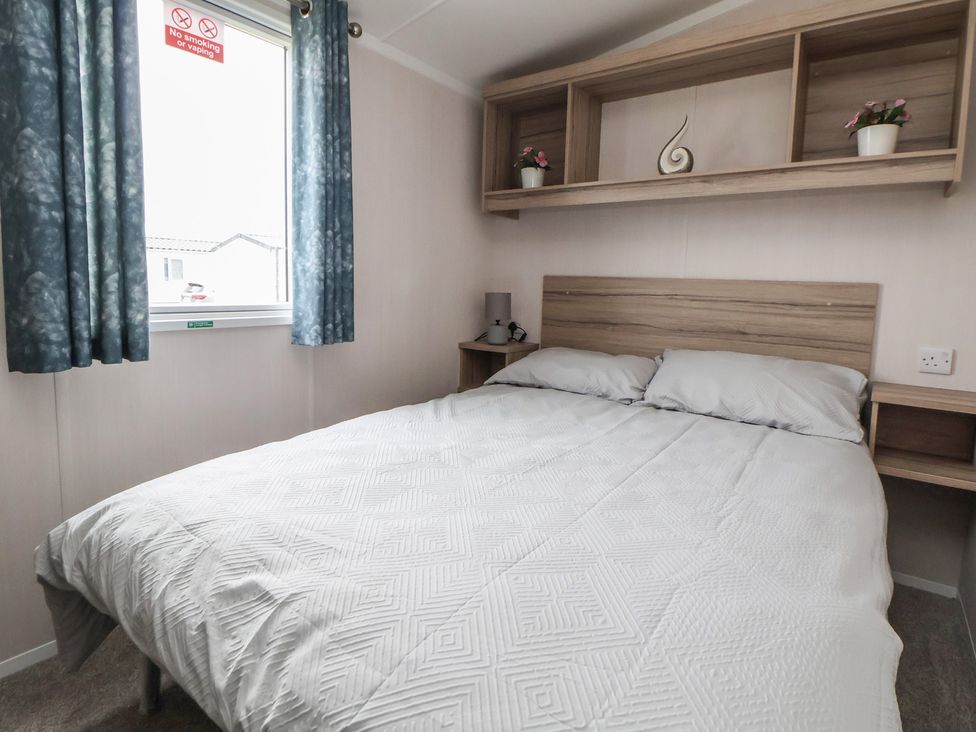 A bedroom with a bed and window at MC15 Rhyl