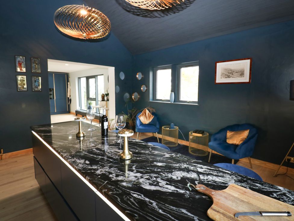 A kitchen with a large island and wine bottle at Chapel Hill in Catlowdy