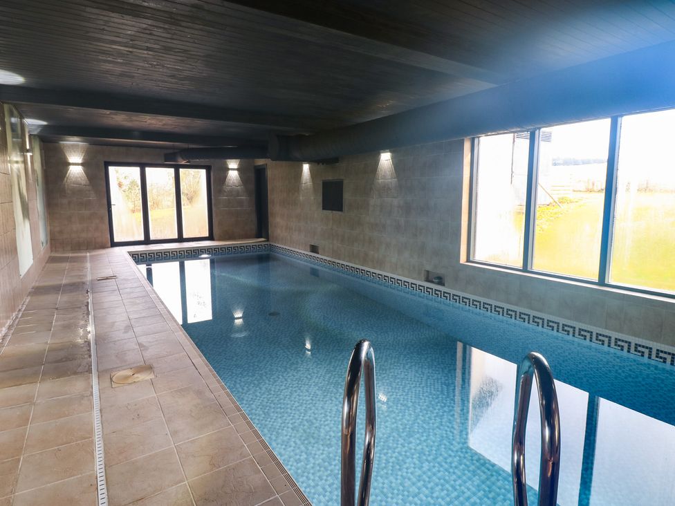 An indoor pool area with windows and a swimming pool at Chapel Hill in Catlowdy