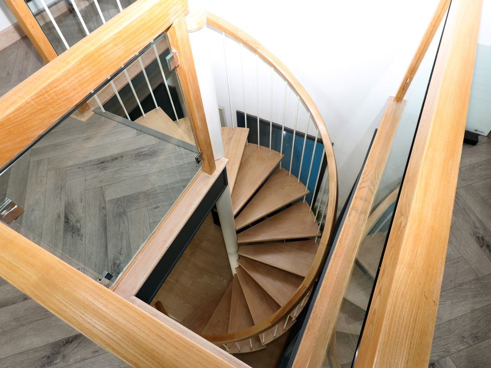 A spiral staircase with a glass railing at Chapel Hill in Catlowdy