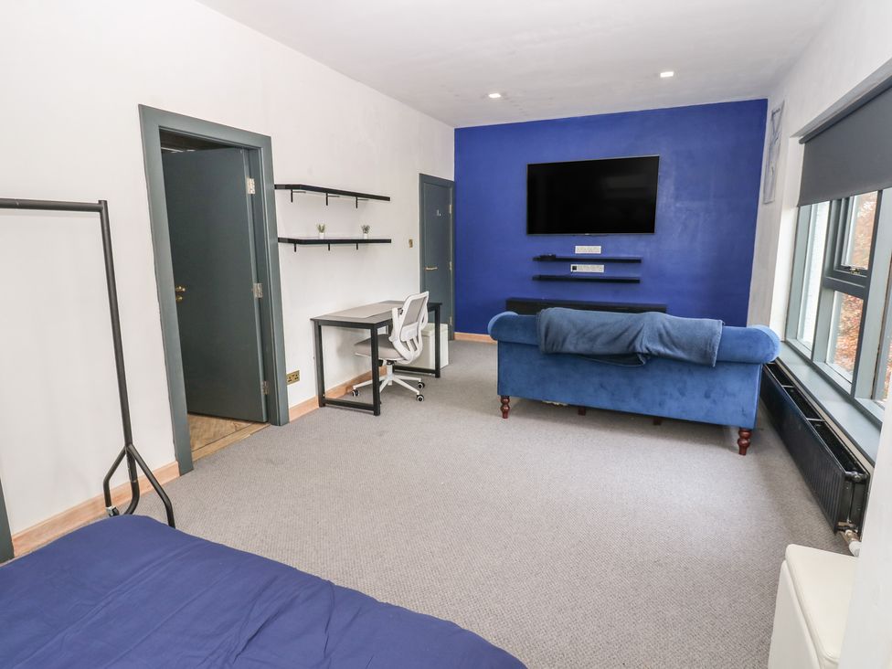 A living room with a desk and sofa at Chapel Hill in Catlowdy