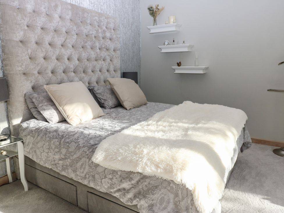 A bedroom with a bed and wall shelves at Chapel Hill, Catlowdy