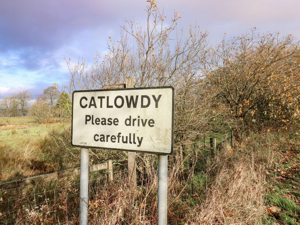 A road sign stating Catlowdy with a caution message at Chapel Hill in Catlowdy