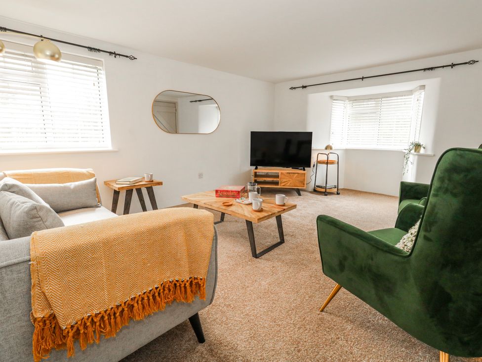A living room with a sofa and coffee table at Long Barn in Burton Bradstock