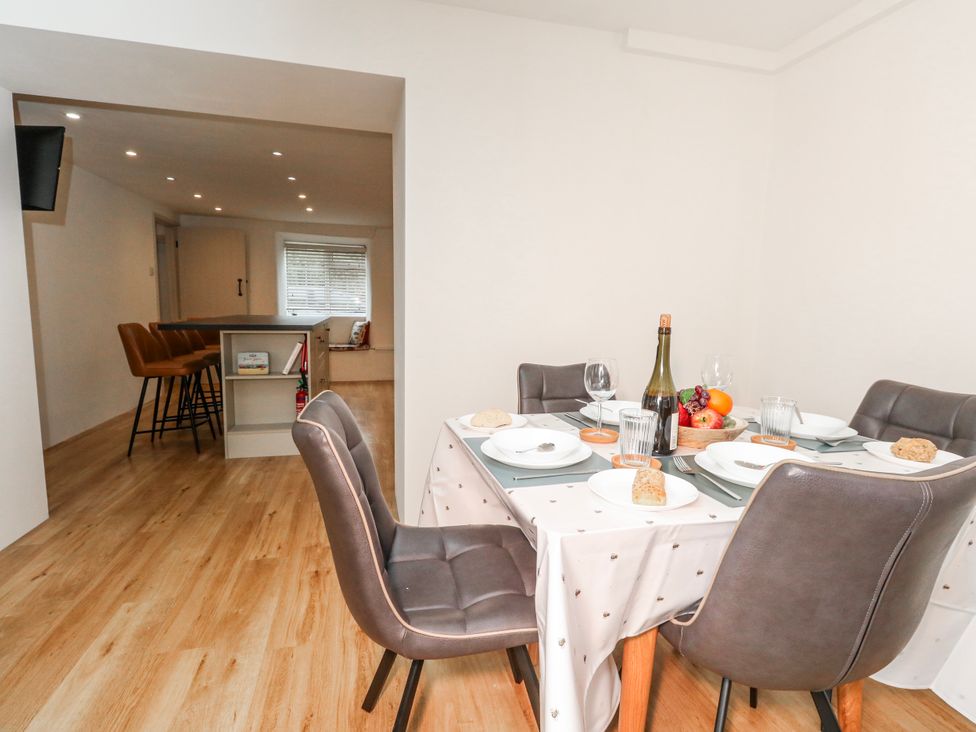 A dining room with a table set for meals at Long Barn in Burton Bradstock