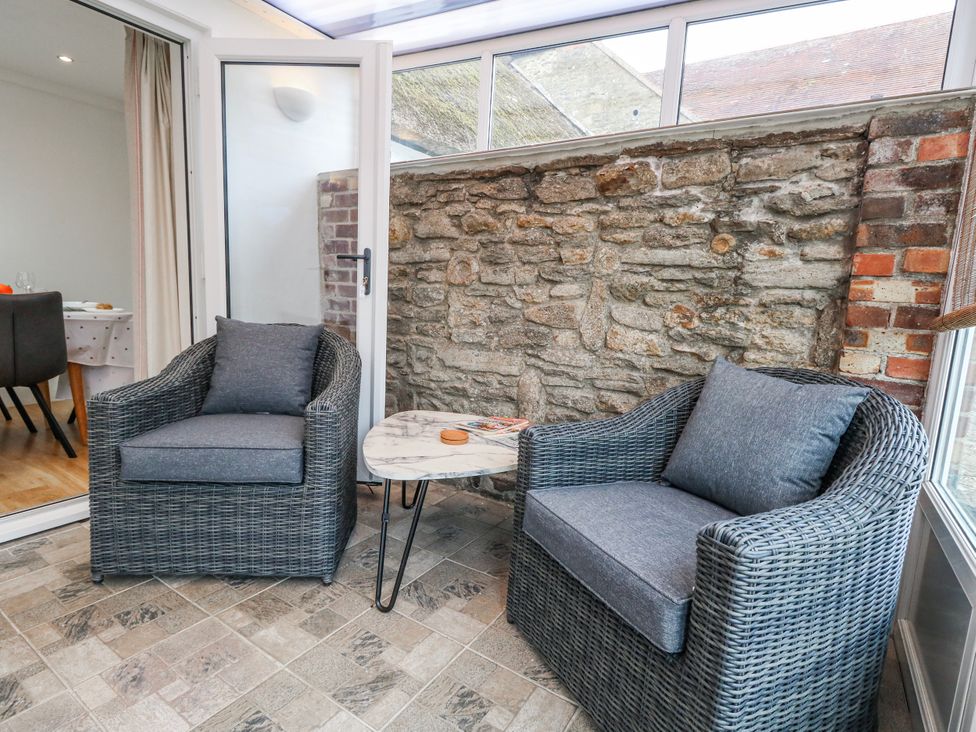 A seating area with two armchairs and a table at Long Barn in Burton Bradstock