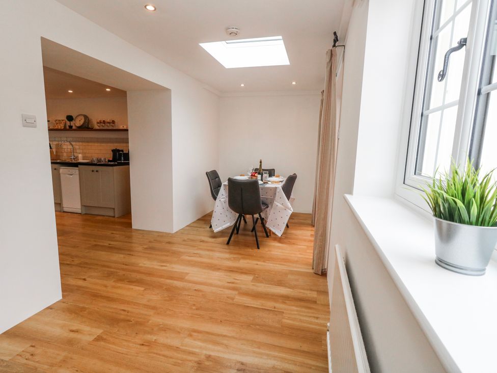 A kitchen with dining area and a window at Long Barn in Burton Bradstock