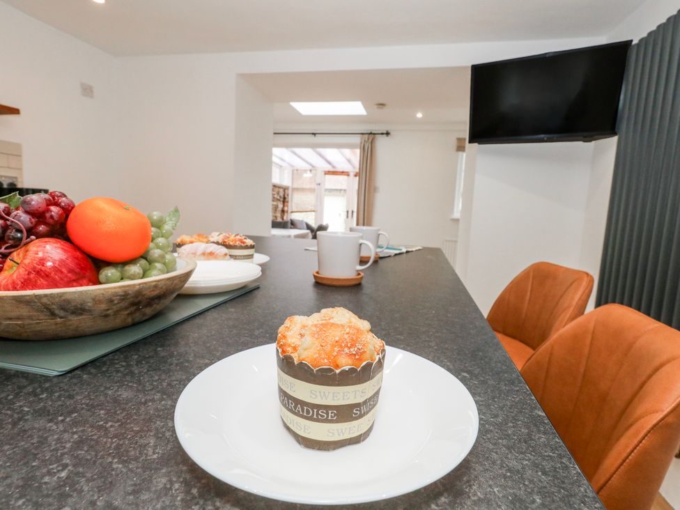 A kitchen with a table and fruit bowl at Long Barn in Burton Bradstock