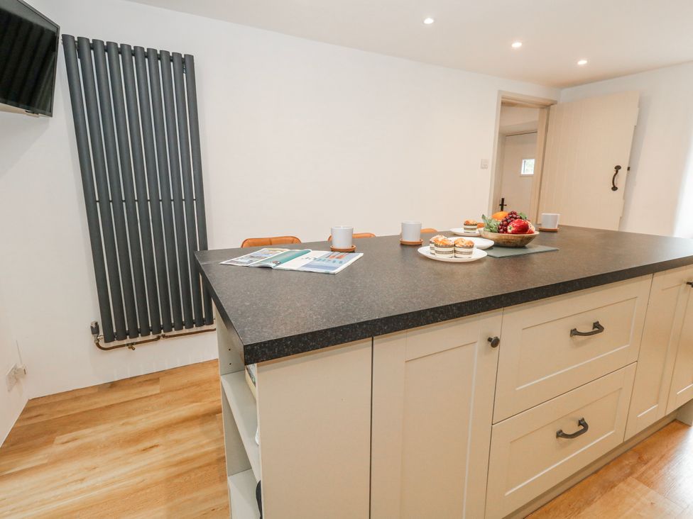 A kitchen with an island and a radiator at Long Barn in Burton Bradstock