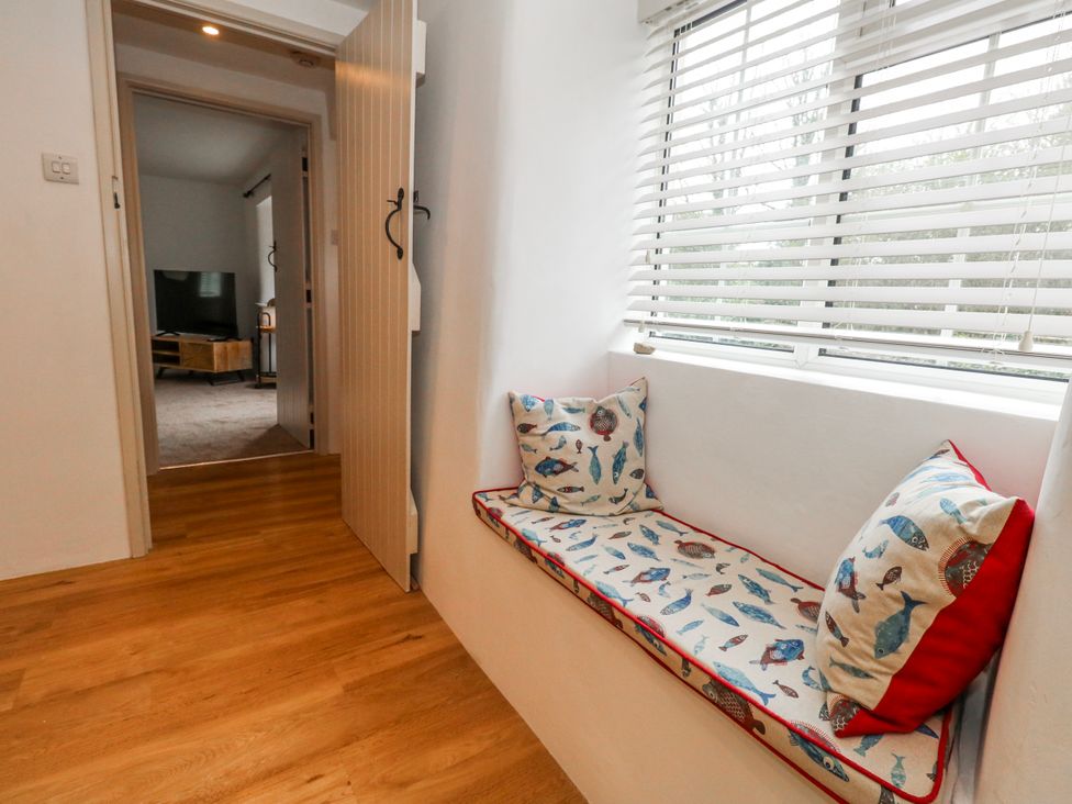 A hallway with a window seat and door at Long Barn in Burton Bradstock