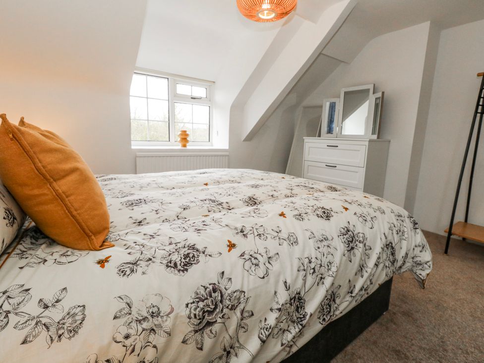 A bedroom with a bed and dresser at Long Barn in Burton Bradstock