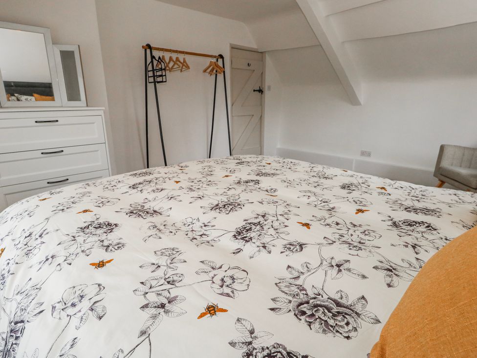 A bedroom with a bed and dresser at Long Barn in Burton Bradstock