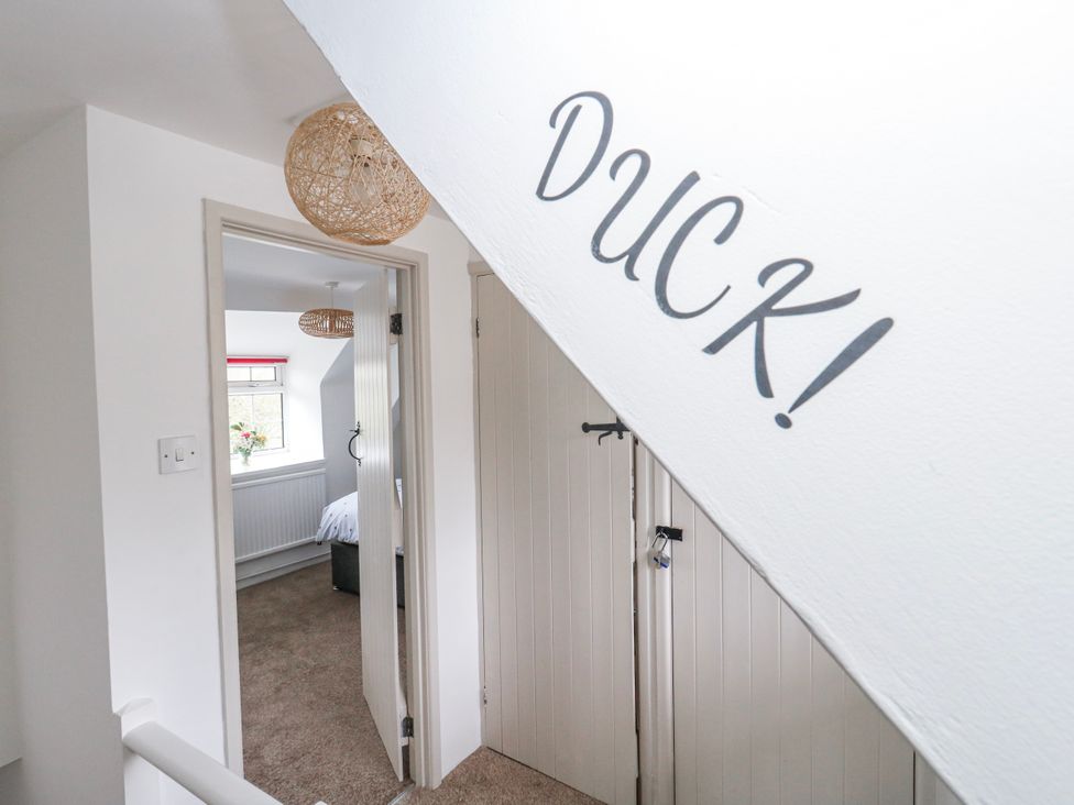 A hallway with a staircase and doors at Long Barn in Burton Bradstock