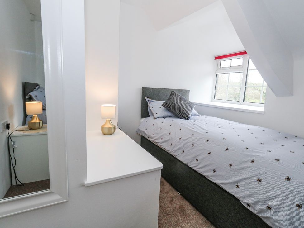 A bedroom with a bed and lamp at Long Barn in Burton Bradstock
