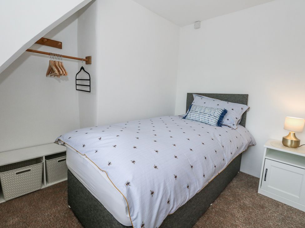 A bedroom with a bed and storage at Long Barn in Burton Bradstock