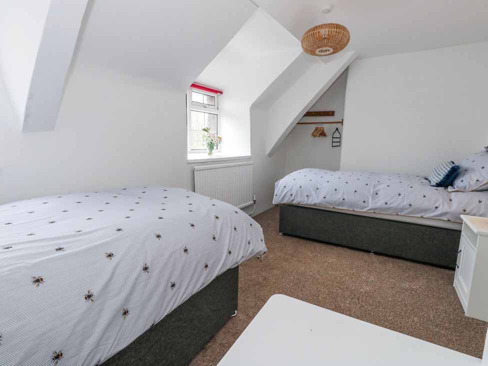 A bedroom with two beds and a window at Long Barn in Burton Bradstock