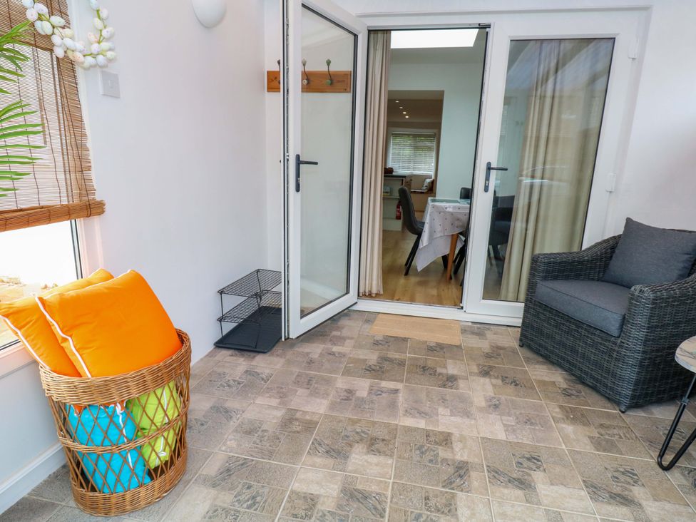 A snug with a chair and a door leading to an outdoor area at Long Barn in Burton Bradstock