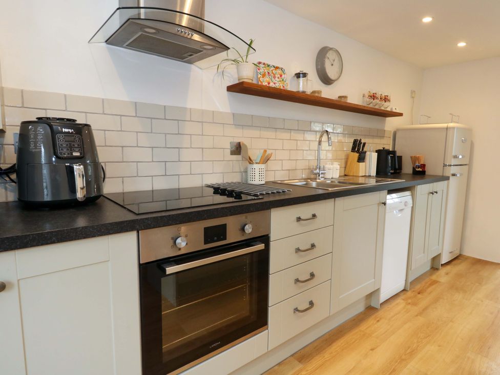 A kitchen with appliances and cabinets at Long Barn in Burton Bradstock