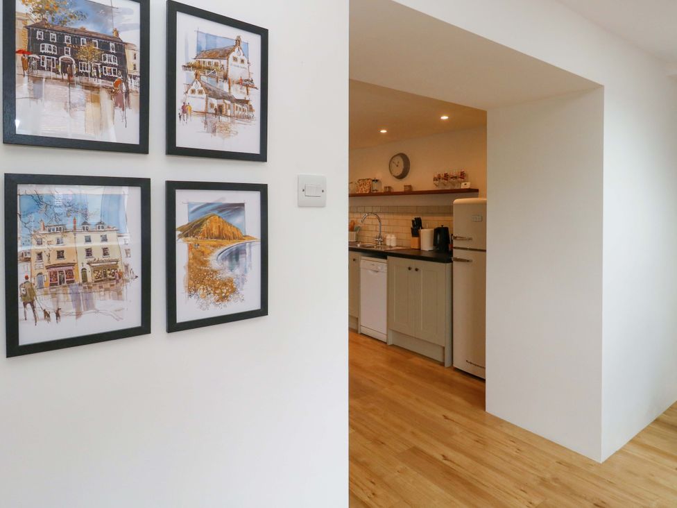 A kitchen with wall art and appliances at Long Barn in Burton Bradstock