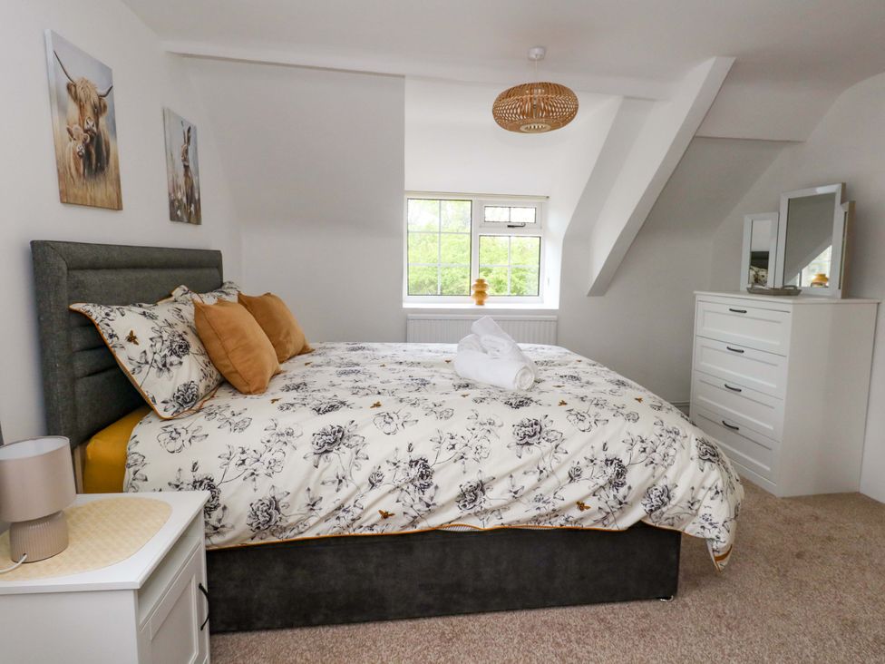A bedroom with a bed and dresser at Long Barn in Burton Bradstock