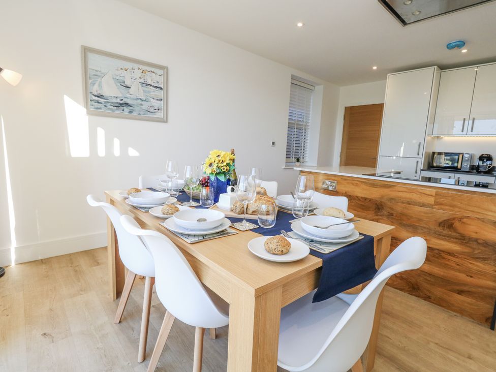 A dining room with a table set for a meal at Seafern House 36B Poole