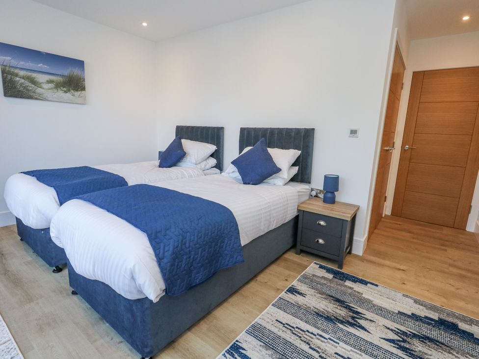 A bedroom with twin beds and a nightstand at Seafern House 36B, Poole